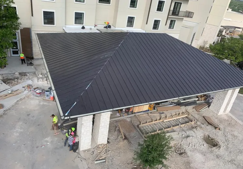Metal roofing installation team working on a commercial building in Corinth